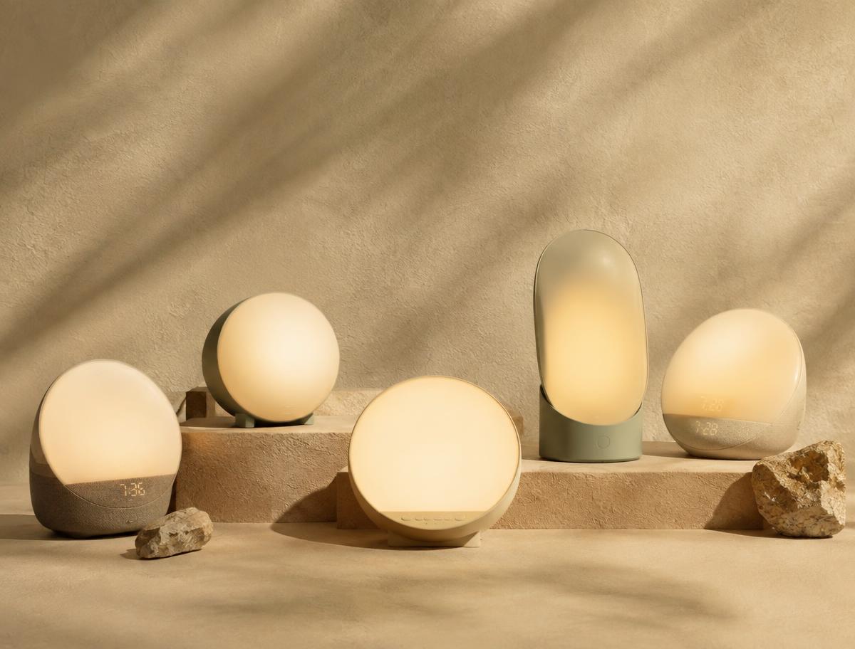 Several sunrise lamps arranged on a sand-coloured plaster surface in morning shadow